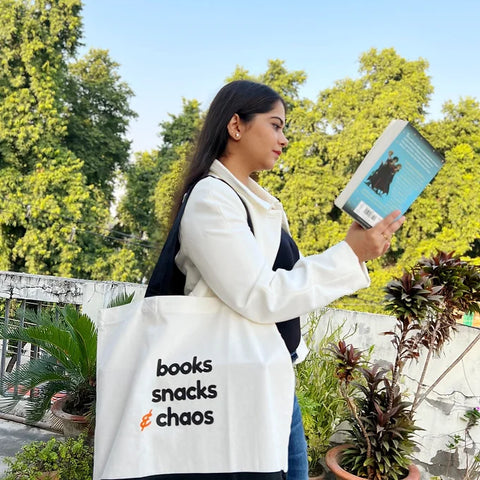 Oversized cotton tote bag with “books snacks & chaos” printed text.