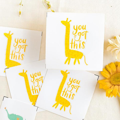 Eco-friendly motivational stickers with yellow giraffe and 'you got this' text, surrounded by yellow flowers