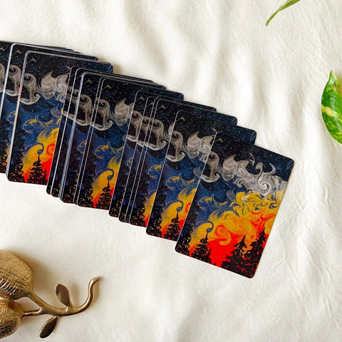 Artistic forest-themed playing card with sunset sky and swirling smoke illustration