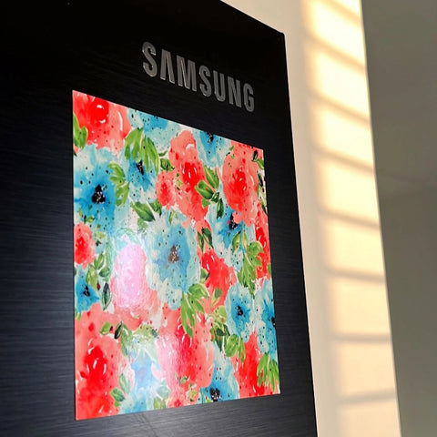 Hand-painted floral magnet with blue and red flowers on a refrigerator