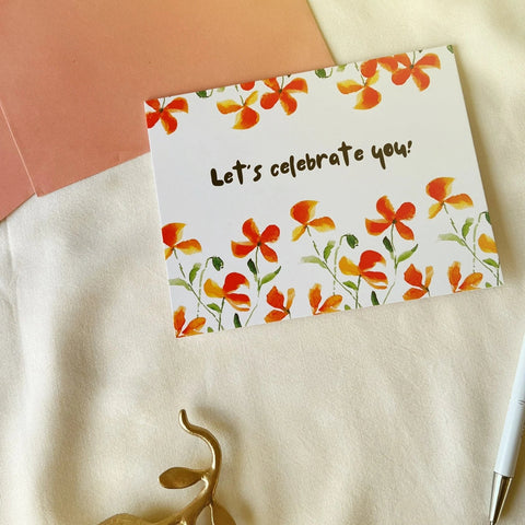 Floral celebration card with bright orange and yellow flowers on a white background