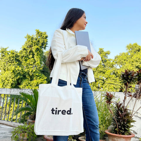 Eco-friendly cotton tote bag featuring the word “tired” in modern typography.