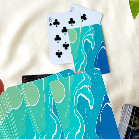 Nature-inspired playing card showing trees against a vivid painted sky.