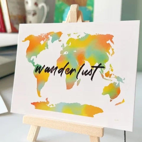 Desk art with a motivational wanderlust quote for workspaces