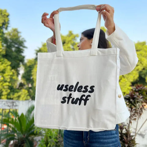 Stylish white tote bag with "useless stuff" printed in bold text